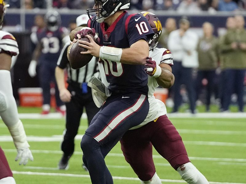 Houston Texans quarterback Davis Mills (10) is sacked by Washington Commanders defensive end Montez Sweat (90) during the second half of an NFL football game Sunday, Nov. 20, 2022, in Houston. (AP Photo/David J. Phillip)