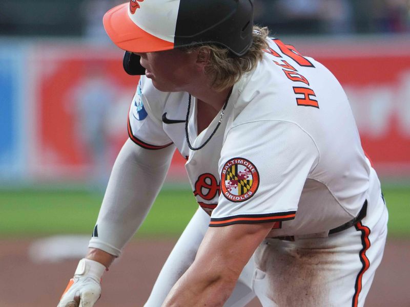 Jun 24, 2025; Baltimore, Maryland, USA; Baltimore Orioles second baseman Jackson Holliday (7) dives back safely following a pickoff attempt during the fourth inning against the Texas Rangers at Oriole Park at Camden Yards. Mandatory Credit: Mitch Stringer-Imagn Images