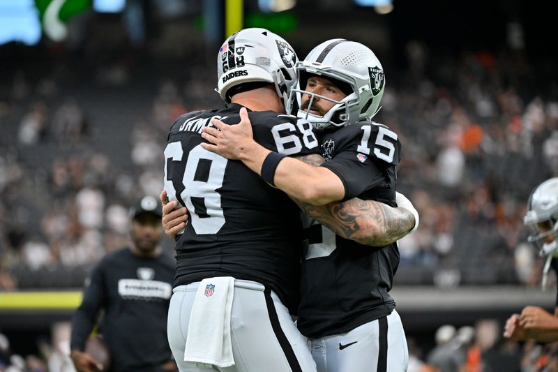 Las Vegas Raiders quarterback Gardner Minshew (15) greets teammate center Andre James before an NFL football game against the Cleveland Browns Sunday, Sept. 29, 2024, in Las Vegas. (AP Photo/David Becker)