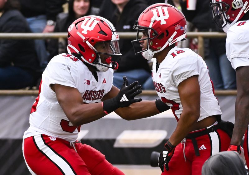 Nov 25, 2023; West Lafayette, Indiana, USA;  Indiana Hoosiers running back David Holloman (33) congratulates Indiana Hoosiers running back Jaylin Lucas (12) after a touchdown during the second half at Ross-Ade Stadium. Mandatory Credit: Robert Goddin-USA TODAY Sports