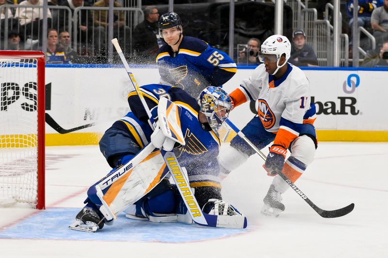 Oct 17, 2024; St. Louis, Missouri, USA;  St. Louis Blues goaltender Joel Hofer (30) defends the net against New York Islanders left wing Anthony Duclair (11) during the first period at Enterprise Center. Mandatory Credit: Jeff Curry-Imagn Images