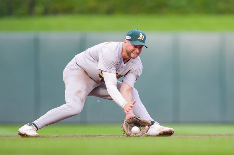 Jun 14, 2024; Minneapolis, Minnesota, USA; Oakland Athletics shortstop Max Schuemann (12) fields a ground ball against the Minnesota Twins in the second inning at Target Field. Mandatory Credit: Brad Rempel-USA TODAY Sports