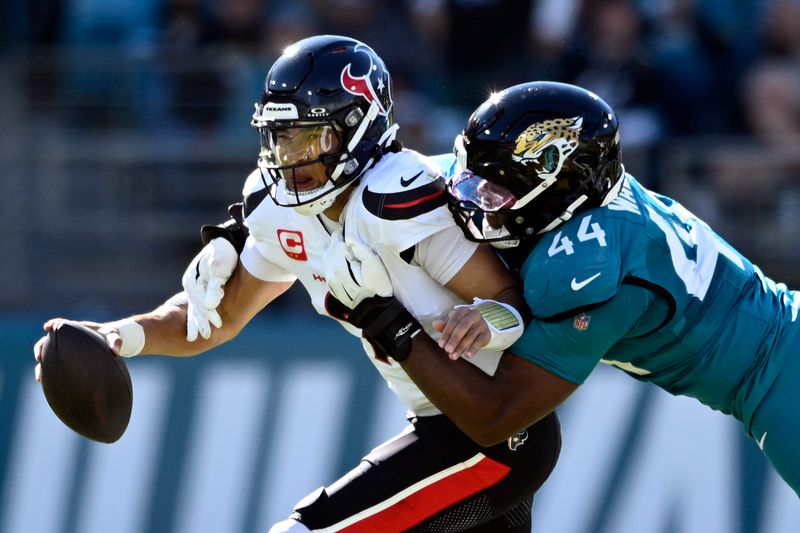 Houston Texans quarterback C.J. Stroud (7) is sacked by Jacksonville Jaguars defensive end Travon Walker (44) during the first half of an NFL football game Sunday, Dec. 1, 2024, in Jacksonville, Fla. (AP Photo/Phelan M. Ebenhack)