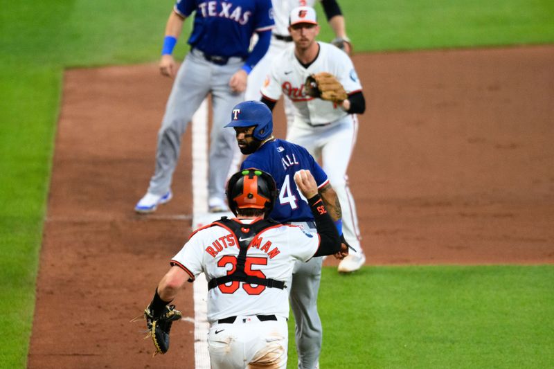 Jun 30, 2024; Baltimore, Maryland, USA; Texas Rangers outfielder Derek Hill (40) is caught in a rundown by Baltimore Orioles catcher Adley Rutschman (35) and third base Jordan Westburg (11) during the fourth inning at Oriole Park at Camden Yards. Mandatory Credit: Reggie Hildred-USA TODAY Sports