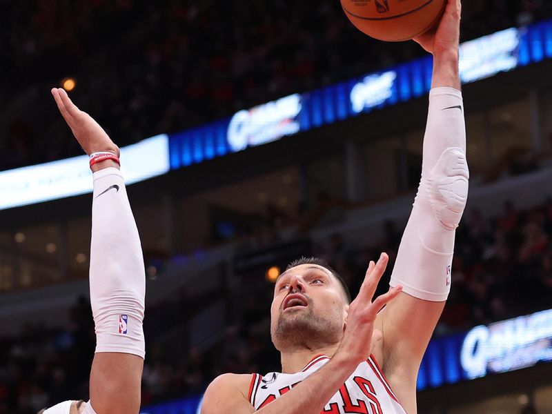 CHICAGO, ILLINOIS - FEBRUARY 26: Nikola Vucevic #9 of the Chicago Bulls shoots over Daniel Gafford #21 of the Washington Wizards during the second half at United Center on February 26, 2023 in Chicago, Illinois. NOTE TO USER: User expressly acknowledges and agrees that, by downloading and or using this photograph, User is consenting to the terms and conditions of the Getty Images License Agreement.  (Photo by Michael Reaves/Getty Images)