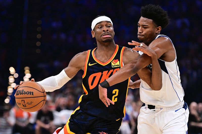 OKLAHOMA CITY, OKLAHOMA - APRIL 14: Shai Gilgeous-Alexander #2 of the Oklahoma City Thunder attempts to drive past Brandon Williams #00 of the Dallas Mavericks during the first half at Paycom Center on April 14, 2024 in Oklahoma City, Oklahoma. NOTE TO USER: User expressly acknowledges and agrees that, by downloading and or using this Photograph, user is consenting to the terms and conditions of the Getty Images License Agreement. (Photo by Joshua Gateley/Getty Images)