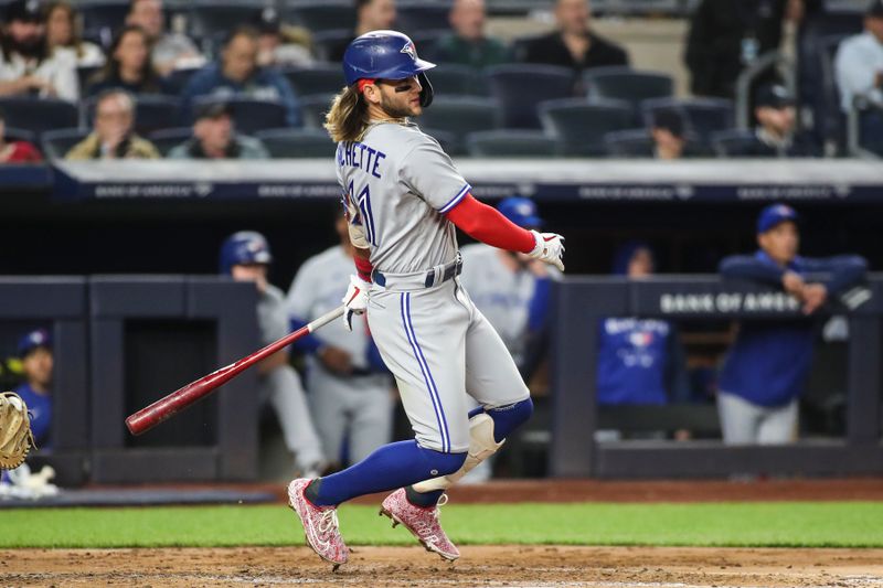 Apr 13, 2022; Bronx, New York, USA;  Toronto Blue Jays shortstop Bo Bichette (11) hits a double in the third inning against the New York Yankees at Yankee Stadium. Mandatory Credit: Wendell Cruz-USA TODAY Sports