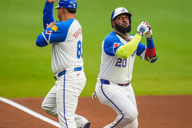 Jul 6, 2024; Cumberland, Georgia, USA; Atlanta Braves designated hitter Marcell Ozuna (20) reacts with third base coach Matt Tuiasosopo (89) after hitting a home run against the Philadelphia Phillies during the first inning at Truist Park. Mandatory Credit: Dale Zanine-USA TODAY Sports