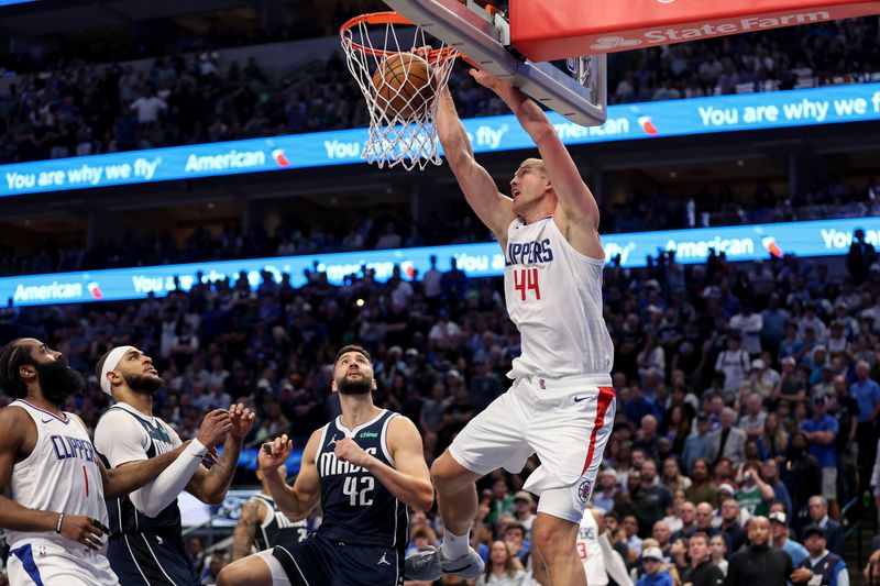 DALLAS, TEXAS - APRIL 28: Mason Plumlee #44 of the Los Angeles Clippers dunks the ball in the second half in front of Maxi Kleber #42 of the Dallas Mavericks  during game four of the Western Conference First Round Playoffs at American Airlines Center on April 28, 2024 in Dallas, Texas.  NOTE TO USER: User expressly acknowledges and agrees that, by downloading and or using this photograph, User is consenting to the terms and conditions of the Getty Images License Agreement. (Photo by Tim Warner/Getty Images)