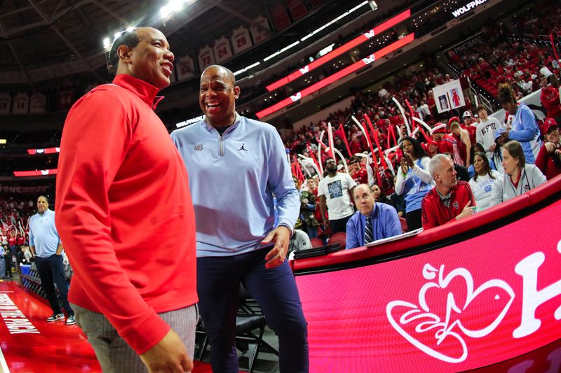 Feb 19, 2023; Raleigh, North Carolina, USA;  North Carolina State Wolfpack head coach Kevin Keatts and North Carolina Tar Heels head coach Hubert Davis interact before the first half of the game at PNC Arena. Mandatory Credit: Jaylynn Nash-USA TODAY Sports