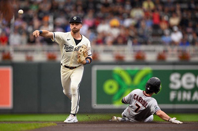 Aug 6, 2023; Minneapolis, Minnesota, USA; Minnesota Twins infielder Edouard Julien (47) throws over sliding Arizona Diamondbacks outfielder Corbin Carroll (7) to complete a double play during the first inning at Target Field. Mandatory Credit: Nick Wosika-USA TODAY Sports