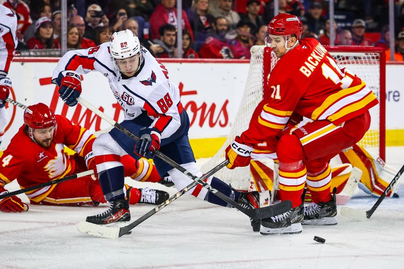 Jan 28, 2025; Calgary, Alberta, CAN; Washington Capitals left wing Andrew Mangiapane (88) passes the puck against Calgary Flames center Mikael Backlund (11) during the third period at Scotiabank Saddledome. Mandatory Credit: Sergei Belski-Imagn Images