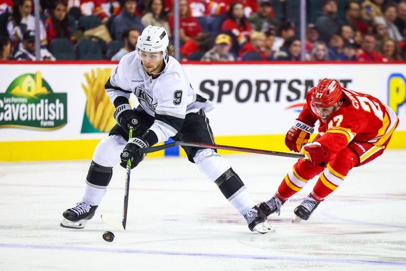 Nov 11, 2024; Calgary, Alberta, CAN; Los Angeles Kings right wing Adrian Kempe (9) controls the puck against Calgary Flames right wing Matt Coronato (27) during the third period at Scotiabank Saddledome. Mandatory Credit: Sergei Belski-Imagn Images