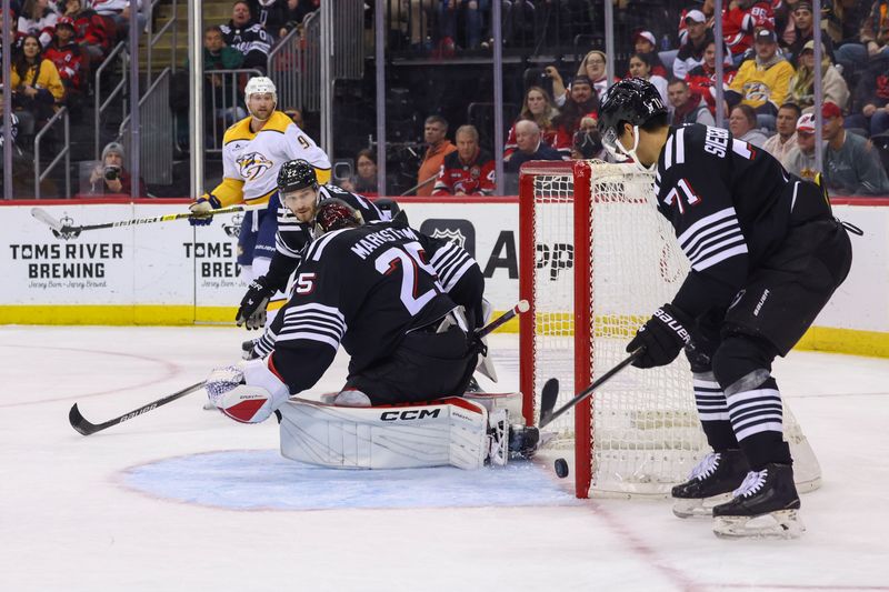 Nov 25, 2024; Newark, New Jersey, USA; The puck rolls wide of the net after a save by New Jersey Devils goaltender Jacob Markstrom (25) against the Nashville Predators during the first period at Prudential Center. Mandatory Credit: Ed Mulholland-Imagn Images