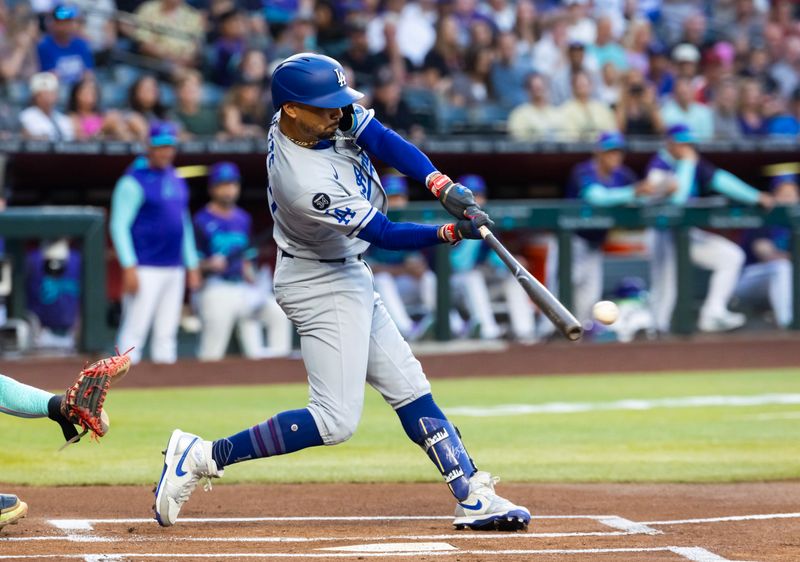 May 9, 2025; Phoenix, Arizona, USA; Los Angeles Dodgers shortstop Mookie Betts hits a first inning single against the Arizona Diamondbacks at Chase Field. Mandatory Credit: Mark J. Rebilas-Imagn Images