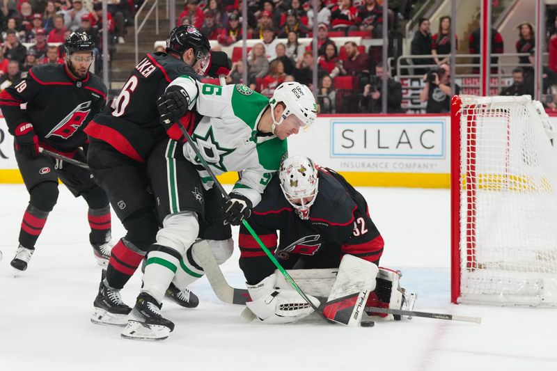 Jan 6, 2026; Raleigh, North Carolina, USA;  Carolina Hurricanes goaltender Brandon Bussi (32) and  defenseman Sean Walker (26) stop the shot by Dallas Stars right wing Mikko Rantanen (96) during the second period at Lenovo Center. Mandatory Credit: James Guillory-Imagn Images