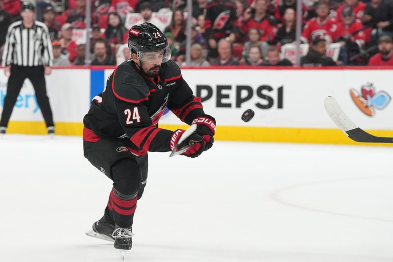 May 20, 2025; Raleigh, North Carolina, USA; Carolina Hurricanes forward Seth Jarvis (24) reaches for the puck -in game one of the Eastern Conference Final of the Florida Panthers forward Evan Rodrigues (17) checks Carolina Hurricanes defenseman Sean Walker (26) during the first period against the Florida Panthers 2025 Stanley Cup Playoffs at Lenovo Center. Mandatory Credit: James Guillory-Imagn Images