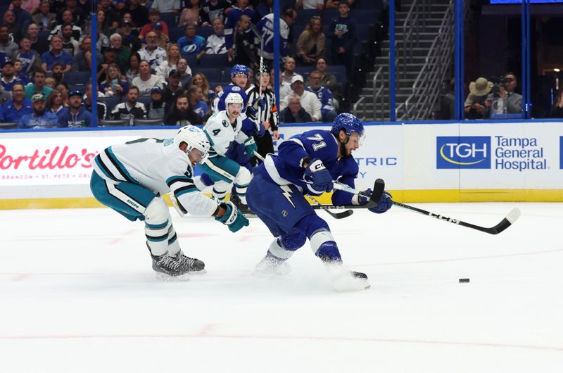 Oct 26, 2023; Tampa, Florida, USA; Tampa Bay Lightning center Anthony Cirelli (71) skates with the puck as San Jose Sharks defenseman Matt Benning (5) defends during the first period at Amalie Arena. Mandatory Credit: Kim Klement Neitzel-USA TODAY Sports