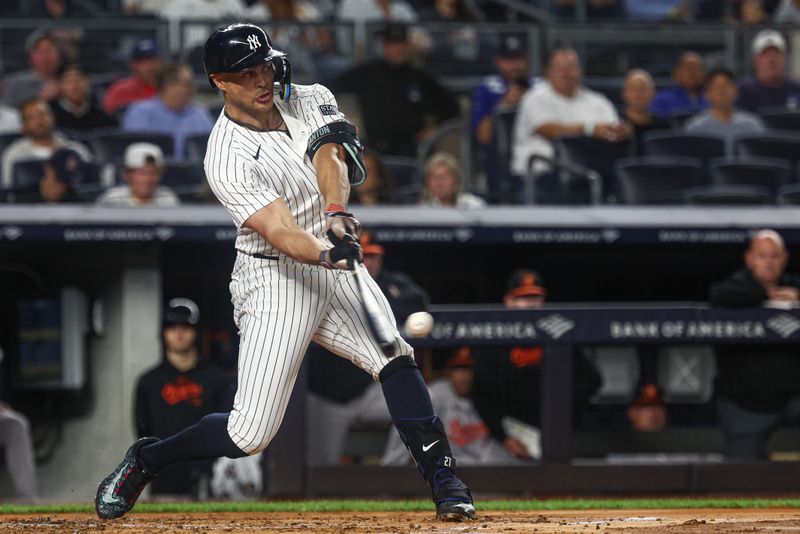 Sep 26, 2024; Bronx, New York, USA; New York Yankees designated hitter Giancarlo Stanton (27) hits a solo home run during the second inning against the Baltimore Orioles at Yankee Stadium. Mandatory Credit: Vincent Carchietta-Imagn Images