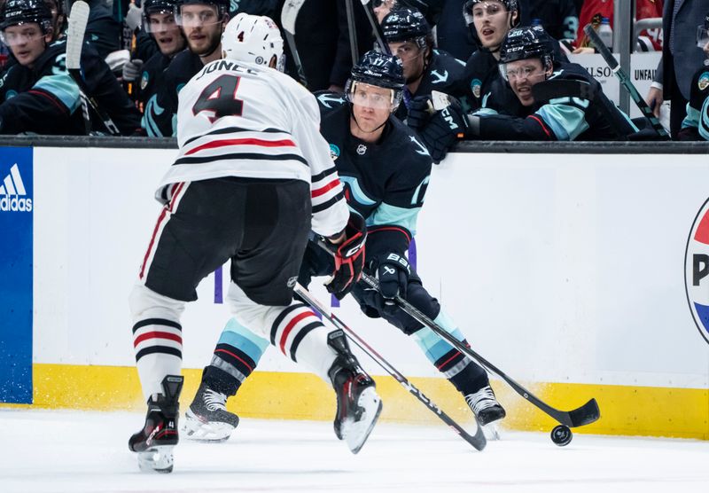 Jan 24, 2024; Seattle, Washington, USA; Seattle Kraken forward Jaden Schwartz (17) skates against Chicago Blackhawks defenseman Seth Jones (4) during the first period at Climate Pledge Arena. Mandatory Credit: Stephen Brashear-USA TODAY Sports