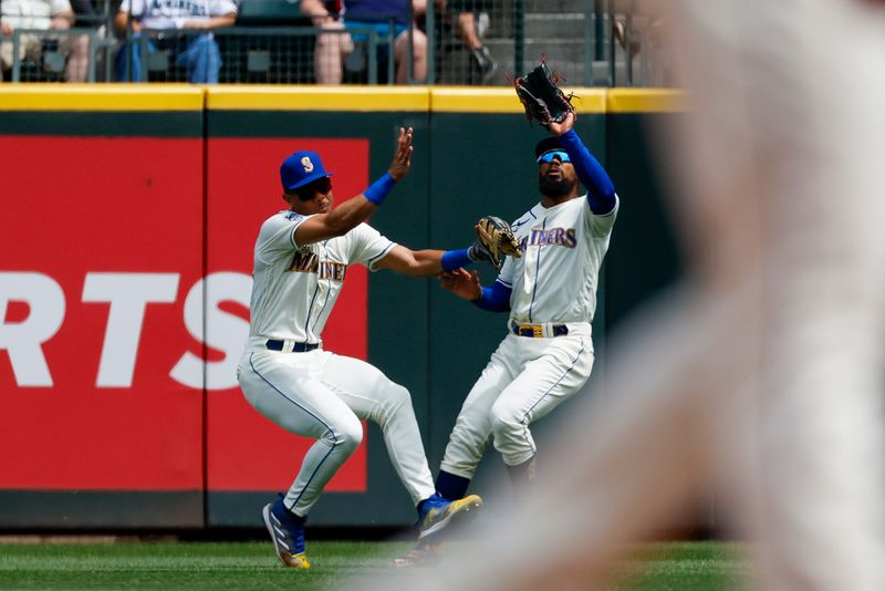 Jul 16, 2023; Seattle, Washington, USA; Seattle Mariners right fielder Teoscar Hernandez (35, right) collides with center fielder Julio Rodriguez (44, left) after catching a fly ball against the Detroit Tigers during the fourth inning at T-Mobile Park. Mandatory Credit: Joe Nicholson-USA TODAY Sports