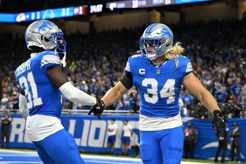 Detroit Lions linebacker Alex Anzalone (34) and Kerby Joseph (31) celebrate a stop against the Los Angeles Rams during the first half of an NFL football game in Detroit, Sunday, Sept. 8, 2024. (AP Photo/David Dermer)