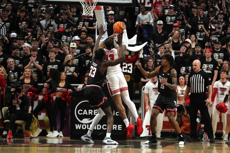 Feb 24, 2025; Lubbock, Texas, USA;  Houston Cougars forward J’Wan Roberts (13) goes to the basket against Texas Tech Red Raiders forward Federiko Federiko (33) in the second half at United Supermarkets Arena. Mandatory Credit: Michael C. Johnson-Imagn Images
