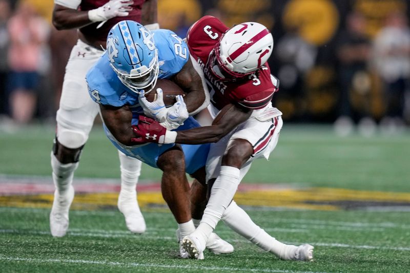 Sep 2, 2023; Charlotte, North Carolina, USA;South Carolina Gamecocks defensive back O'Donnell Fortune (3) tackles North Carolina Tar Heels running back British Brooks (24) during the first quarter at Bank of America Stadium. Mandatory Credit: Jim Dedmon-USA TODAY Sports