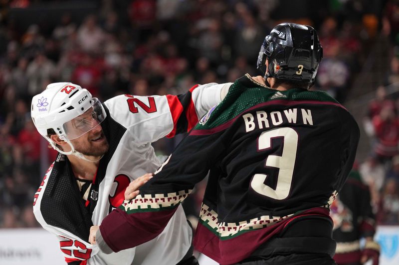 Mar 16, 2024; Tempe, Arizona, USA; New Jersey Devils left wing Kurtis MacDermid (23) and Arizona Coyotes defenseman Josh Brown (3) fight during the third period at Mullett Arena. Mandatory Credit: Joe Camporeale-USA TODAY Sports