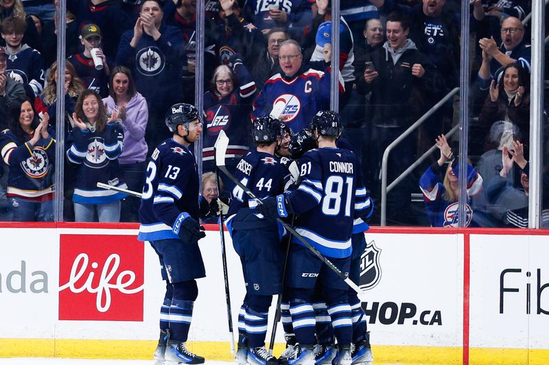 Jan 24, 2025; Winnipeg, Manitoba, CAN;  Winnipeg Jets forward Cole Perfetti (91) is congratulated by his teammates on his goal against the Utah Hockey Club during the first period at Canada Life Centre. Mandatory Credit: Terrence Lee-Imagn Images