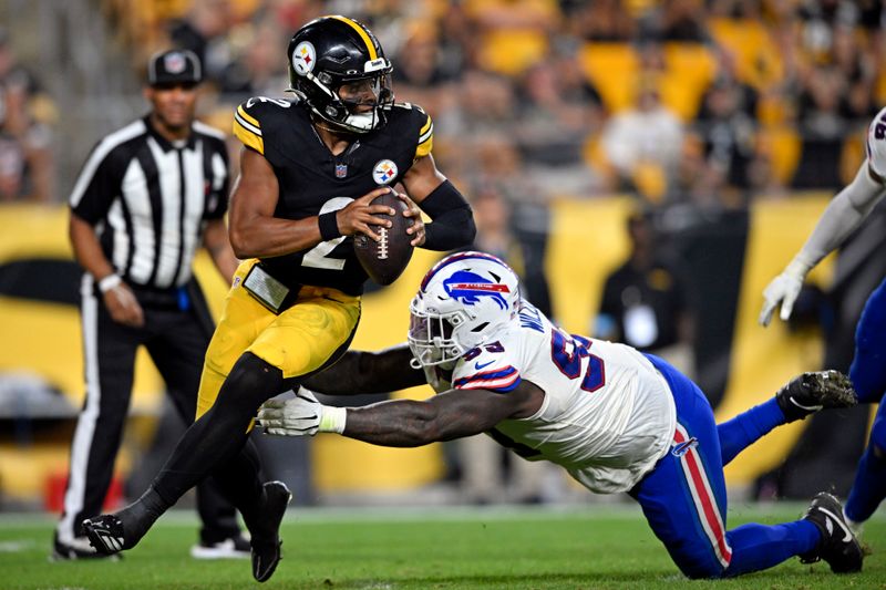 Pittsburgh Steelers quarterback Justin Fields (2) scrambles out of the grasp of Buffalo Bills defensive end Kingsley Jonathan (59) during the second half of an NFL preseason football game, Saturday, Aug. 17, 2024, in Pittsburgh. (AP Photo/David Dermer)