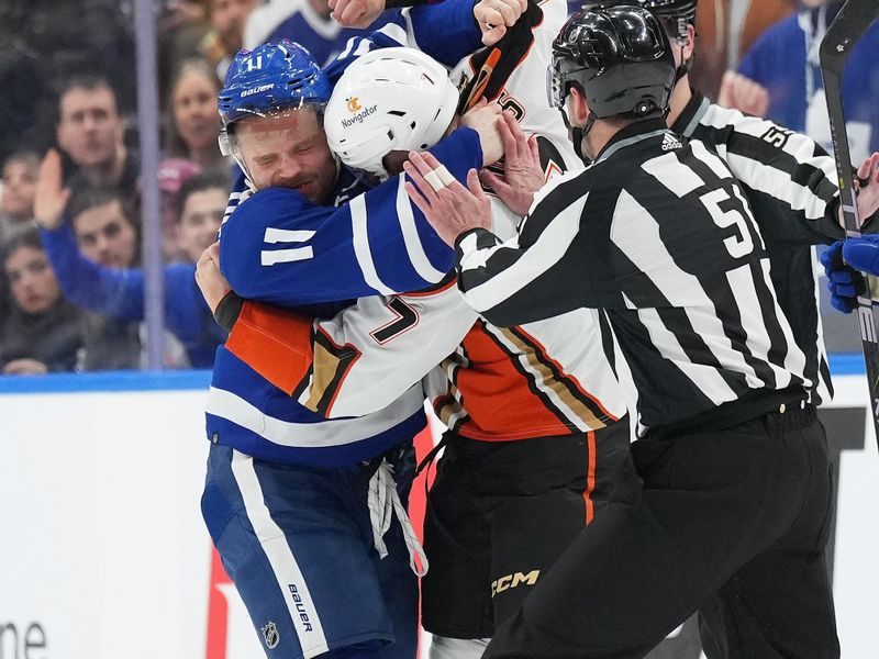 Feb 17, 2024; Toronto, Ontario, CAN; Toronto Maple Leafs center Max Domi (11) fights with Anaheim Ducks defenseman Radko Gudas (7) during the first period at Scotiabank Arena. Mandatory Credit: Nick Turchiaro-USA TODAY Sports