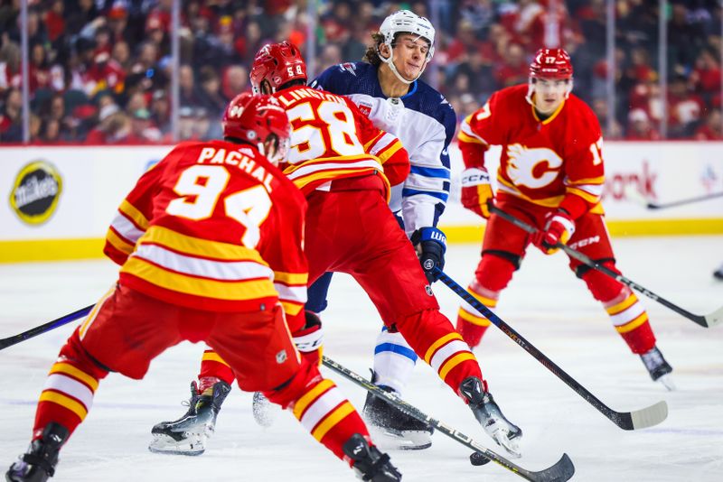 Feb 19, 2024; Calgary, Alberta, CAN; Winnipeg Jets center Morgan Barron (36) and Calgary Flames defenseman Oliver Kylington (58) battles for the puck during the first period at Scotiabank Saddledome. Mandatory Credit: Sergei Belski-USA TODAY Sports