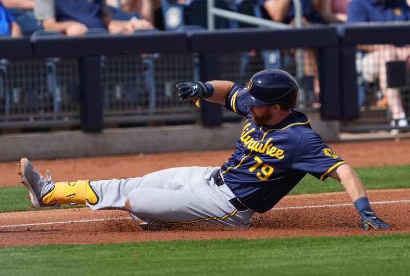 Feb 24, 2024; Peoria, Arizona, USA; Milwaukee Brewers second baseman Oliver Dunn (79) slips into third base with a triple against the San Diego Padres during the second inning of a Spring Training game at Peoria Sports Complex. Mandatory Credit: Joe Camporeale-USA TODAY Sports