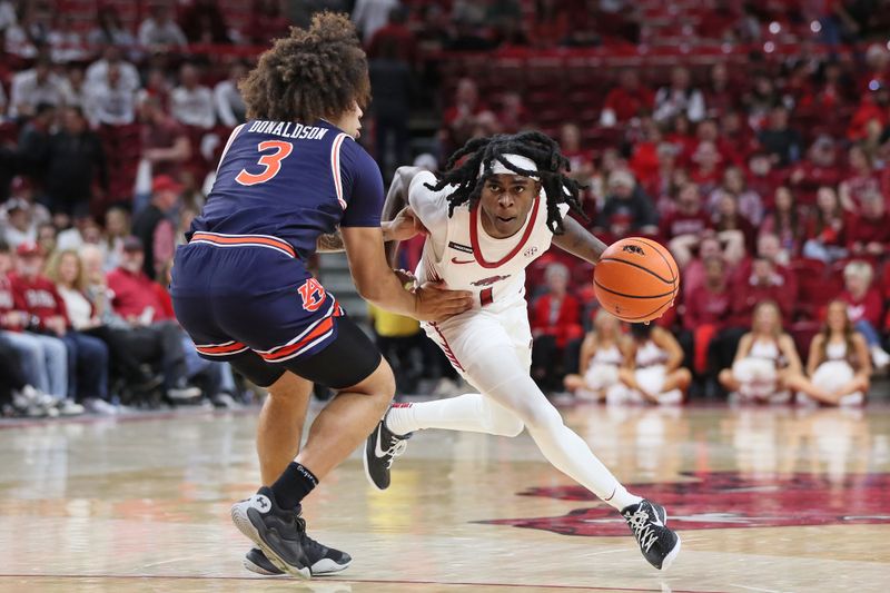 Jan 6, 2024; Fayetteville, Arkansas, USA; Arkansas Razorbacks guard Keyon Menifield Jr (1) drives against  Auburn Tigers guard Tre Donaldson (3) during the second half at Bud Walton Arena. Auburn won 83-51. Mandatory Credit: Nelson Chenault-USA TODAY Sports