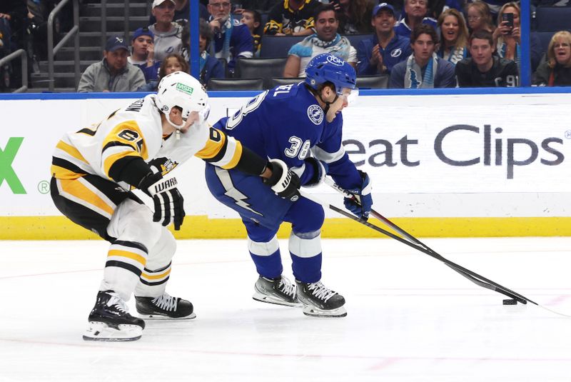 Dec 6, 2023; Tampa, Florida, USA; Tampa Bay Lightning left wing Brandon Hagel (38) skates with the puck as Pittsburgh Penguins defenseman Erik Karlsson (65) defends during the third period at Amalie Arena. Mandatory Credit: Kim Klement Neitzel-USA TODAY Sports