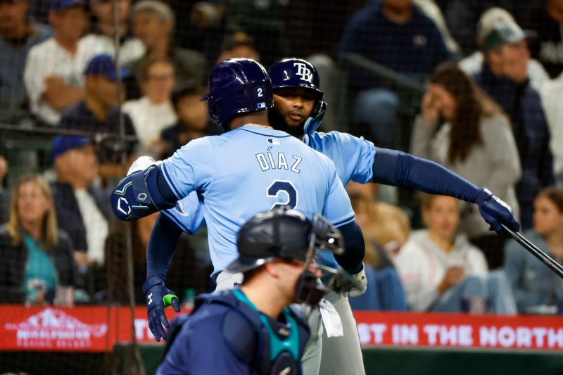 Aug 27, 2024; Seattle, Washington, USA; Tampa Bay Rays first baseman Yandy Diaz (2) hugs third baseman Junior Caminero (13) after hitting a solo-home run against the Seattle Mariners during the eighth inning at T-Mobile Park. Mandatory Credit: Joe Nicholson-USA TODAY Sports