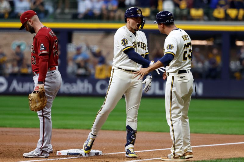 Oct 4, 2023; Milwaukee, Wisconsin, USA; Milwaukee Brewers shortstop Willy Adames (27) reacts with first base coach Quintin Berry (23) at first base in the first inning against the Arizona Diamondbacks during game two of the Wildcard series for the 2023 MLB playoffs at American Family Field. Mandatory Credit: Kamil Krzaczynski-USA TODAY Sports