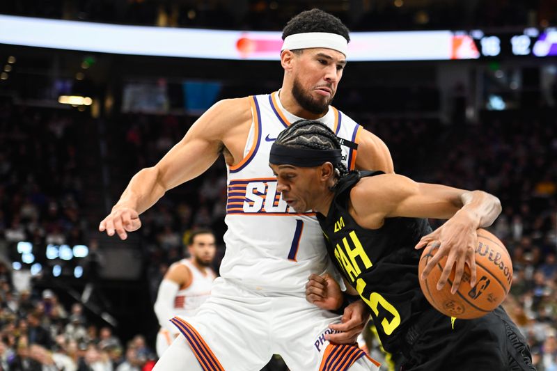 SALT LAKE CITY, UTAH - NOVEMBER 12: Cody Williams #5 of the Utah Jazz drives into Devin Booker #1 of the Phoenix Suns during the first half of an Emirates NBA Cup game at Delta Center on November 12, 2024 in Salt Lake City, Utah. NOTE TO USER: User expressly acknowledges and agrees that, by downloading and or using this photograph, User is consenting to the terms and conditions of the Getty Images License Agreement. (Photo by Alex Goodlett/Getty Images)