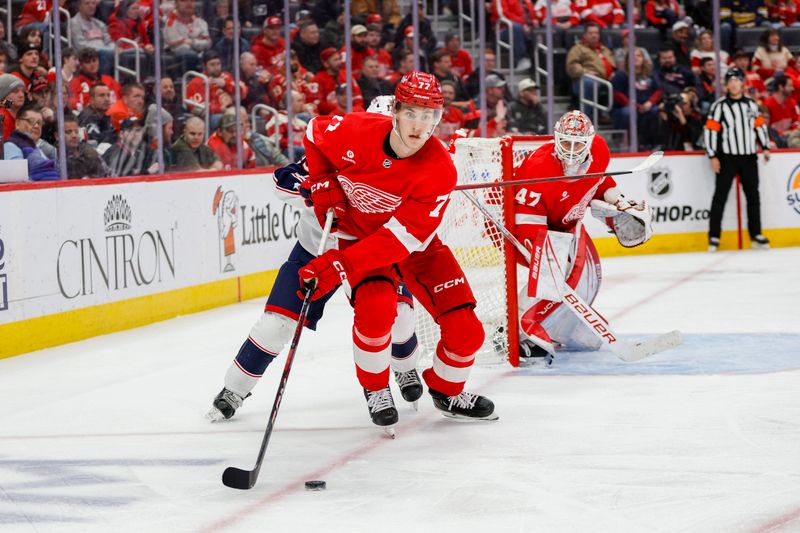 Mar 19, 2024; Detroit, Michigan, USA; Detroit Red Wings defenseman Simon Edvinsson (77) handles the puck during the third period of the game against the Columbus Blue Jackets at Little Caesars Arena. Mandatory Credit: Brian Bradshaw Sevald-USA TODAY Sports