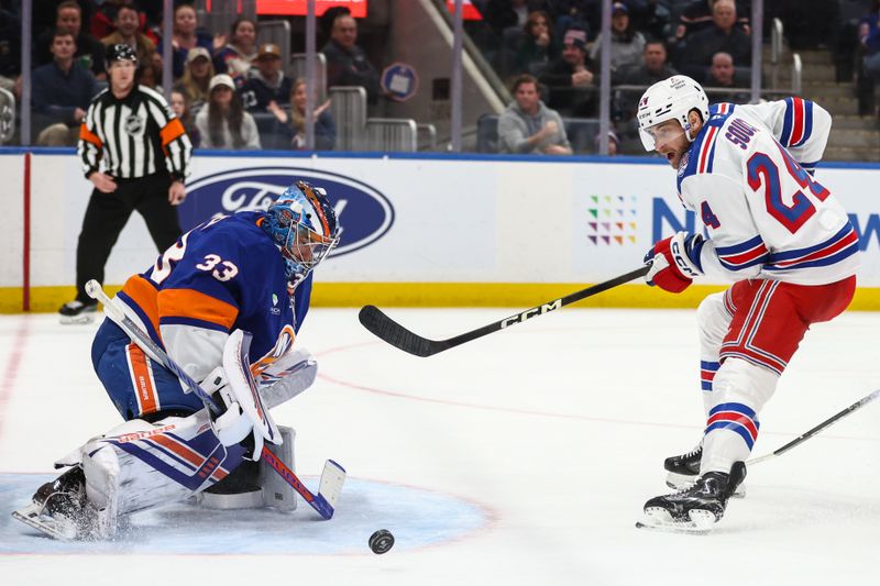 Dec 27, 2025; Elmont, New York, USA;  New York Islanders goaltender David Rittich (33) makes a save on a shot on goal attempt from New York Rangers defenseman Carson Soucy (24) in the third period at UBS Arena. Mandatory Credit: Wendell Cruz-Imagn Images