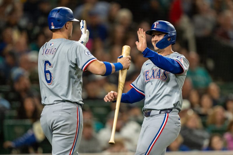 Sep 13, 2024; Seattle, Washington, USA;  Texas Rangers centerfielder Wyatt Langford (36) is congratulated by third baseman Josh Jung (6) after scoring a run during the seventh inning against the Seattle Mariners at T-Mobile Park. Mandatory Credit: Stephen Brashear-Imagn Images