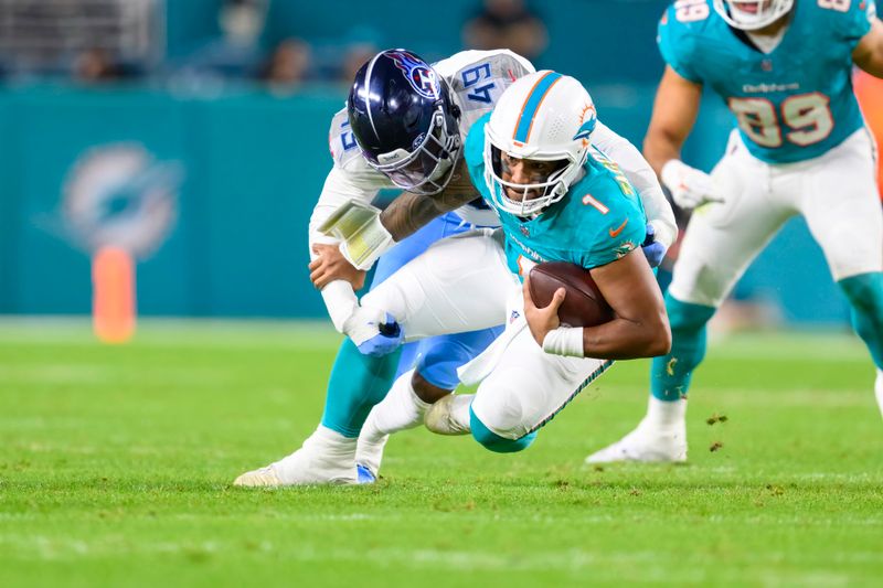 Tennessee Titans linebacker Arden Key (49) sacks Miami Dolphins quarterback Tua Tagovailoa (1) during an NFL football game Monday, Dec. 12, 2023, in Miami Gardens, Fla. (AP Photo/Doug Murray)