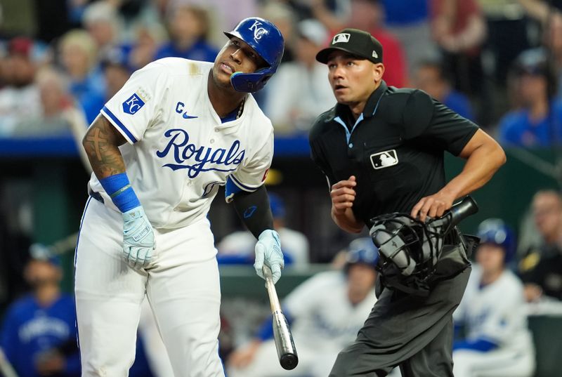 Aug 10, 2024; Kansas City, Missouri, USA; Kansas City Royals first baseman Salvador Perez (13) and umpire Roberto Ortiz (40) watch a foul ball during the eighth inning against the St. Louis Cardinals at Kauffman Stadium. Mandatory Credit: Jay Biggerstaff-USA TODAY Sports