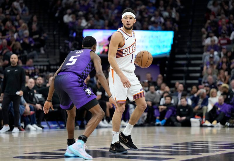 SACRAMENTO, CALIFORNIA - APRIL 12: Devin Booker #1 of the Phoenix Suns dribbling the ball is guarded by De'Aaron Fox #5 of the Sacramento Kings during the first half of an NBA basketball game at Golden 1 Center on April 12, 2024 in Sacramento, California. NOTE TO USER: User expressly acknowledges and agrees that, by downloading and or using this photograph, User is consenting to the terms and conditions of the Getty Images License Agreement. (Photo by Thearon W. Henderson/Getty Images)