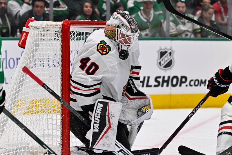 Nov 7, 2024; Dallas, Texas, USA; Chicago Blackhawks goaltender Arvid Soderblom (40) is hit in the face mask on a shot by Dallas Stars center Logan Stankoven (11) during the second period at the American Airlines Center. Mandatory Credit: Jerome Miron-Imagn Images