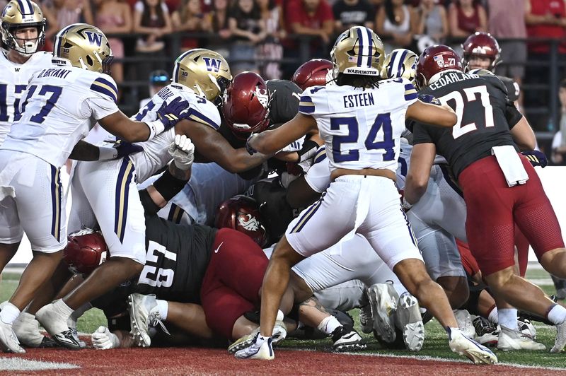 Sep 20, 2025; Pullman, Washington, USA; Washington Huskies running back Jordan Washington (4) leaps into the end zone for a touchdown against the Washington Huskies in the second half of Apple Cup at Gesa Field at Martin Stadium. Washington Huskies won 59-24. Mandatory Credit: James Snook-Imagn Images