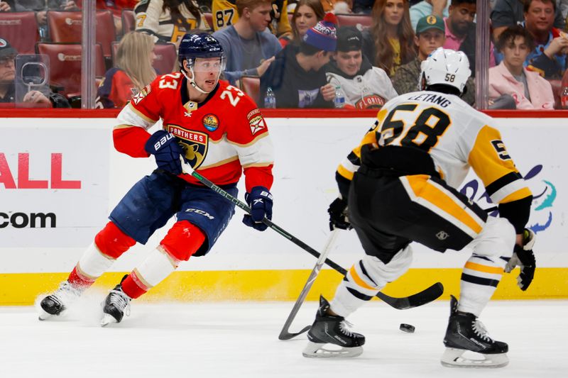 Dec 15, 2022; Sunrise, Florida, USA; Florida Panthers center Carter Verhaeghe (23) controls the puck as Pittsburgh Penguins defenseman Kris Letang (58) defends during the second period at FLA Live Arena. Mandatory Credit: Sam Navarro-USA TODAY Sports