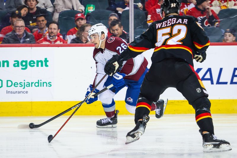 Mar 12, 2024; Calgary, Alberta, CAN; Colorado Avalanche defenseman Sean Walker (26) controls the puck against Calgary Flames defenseman MacKenzie Weegar (52) during the third period at Scotiabank Saddledome. Mandatory Credit: Sergei Belski-USA TODAY Sports