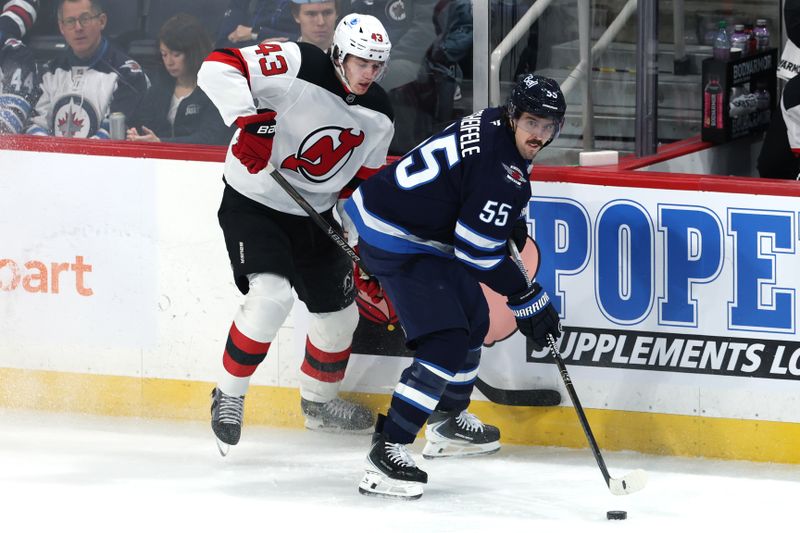 Jan 11, 2026; Winnipeg, Manitoba, CAN; Winnipeg Jets center Mark Scheifele (55) is checked by New Jersey Devils defenseman Luke Hughes (43) in the first period at Canada Life Centre. Mandatory Credit: James Carey Lauder-Imagn Images